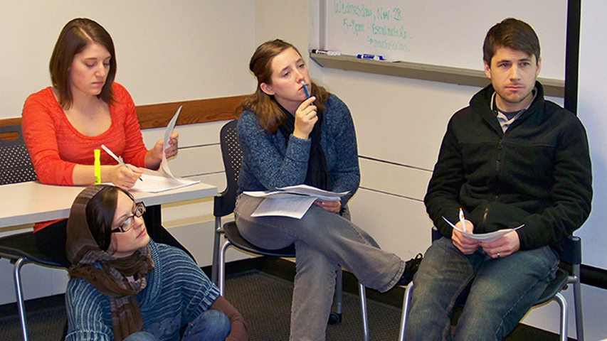 Illinois State students Ashley Toenjes, below left, Alex Trimble, left, Raina Kirchner, and Jeff Koch prepare the presentation of their class’s report: “Food Insecurity in Bloomington-Normal: How a Grocery Cooperative Might Help Meet the Needs of Low-Income Residents.”