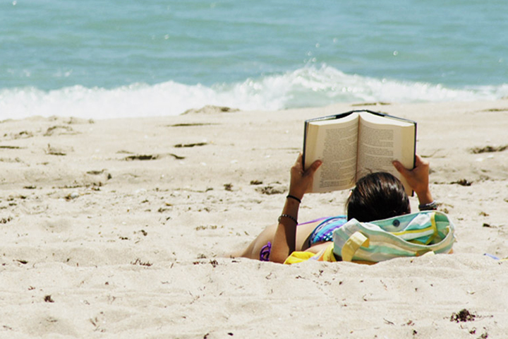 Woman reads on a beach