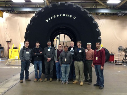 Engineering technology students in front of a 15,000-pound tire