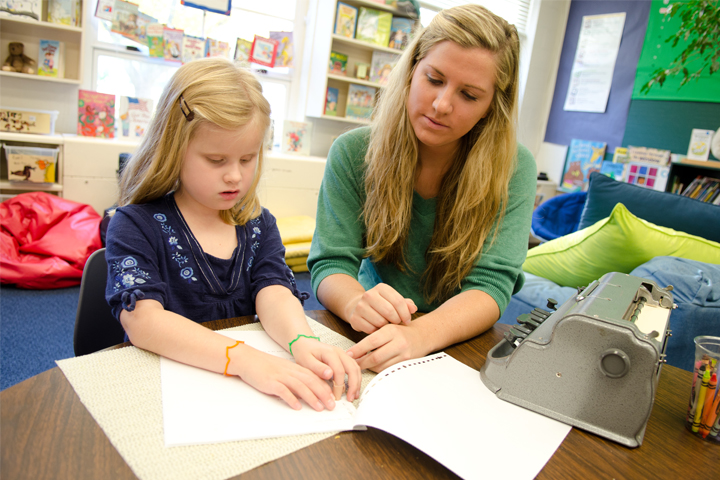 A teacher candidate in the Department of Special Education works with a Thomas Metcalf School student in the low vision and blindness program.