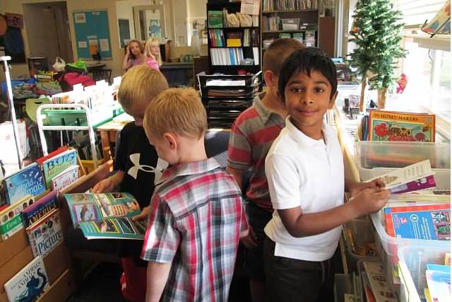 First grade students choose books.