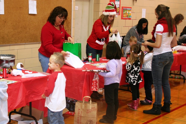 Metcalf students watch as volunteers wrap their gifts during the Holiday Bazaar.