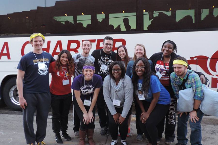 ASB students pose in front of bus