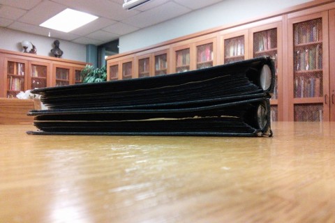 two black binders on wooden desk