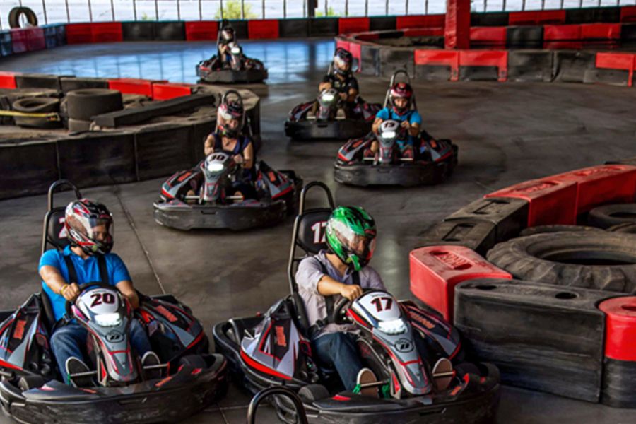 six people driving on go-kart track
