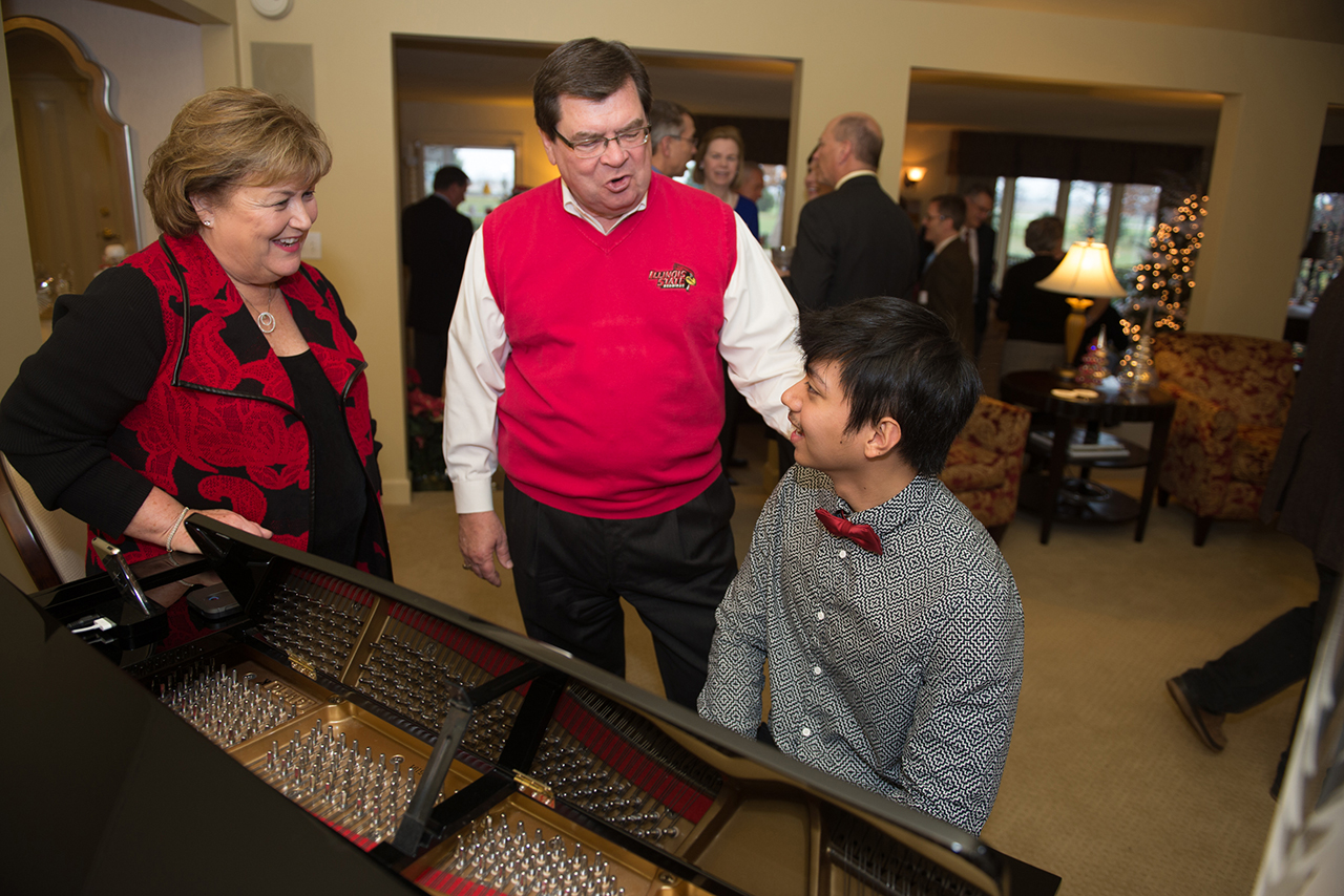University President Larry Dietz and his wife, Marlene, talk to School of Music pianist Dominique Gonzales at an event December 13 at the University