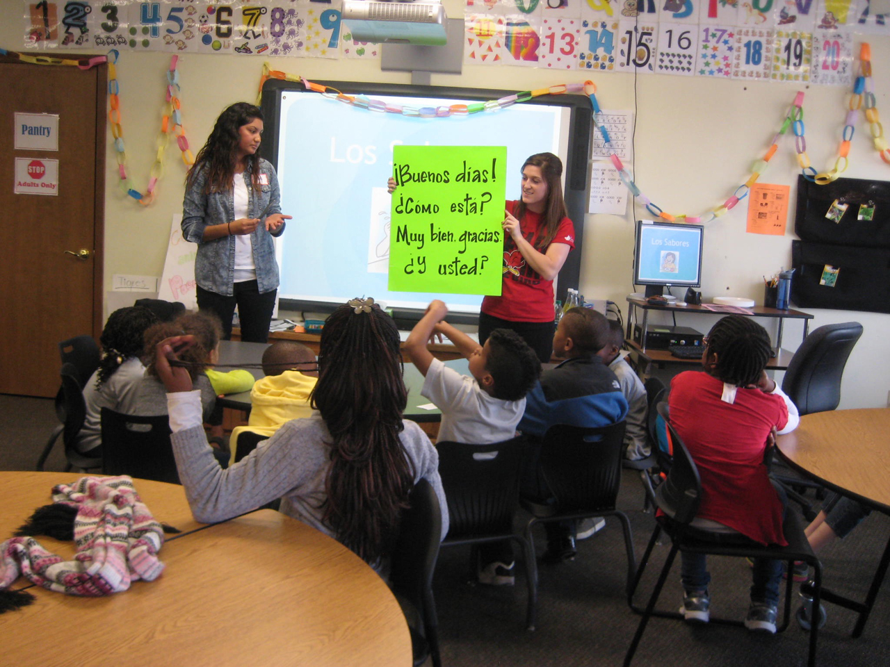 image of students from Illinois State's Languages, Literatures, and Cultures work with students from Unity Community Center.
