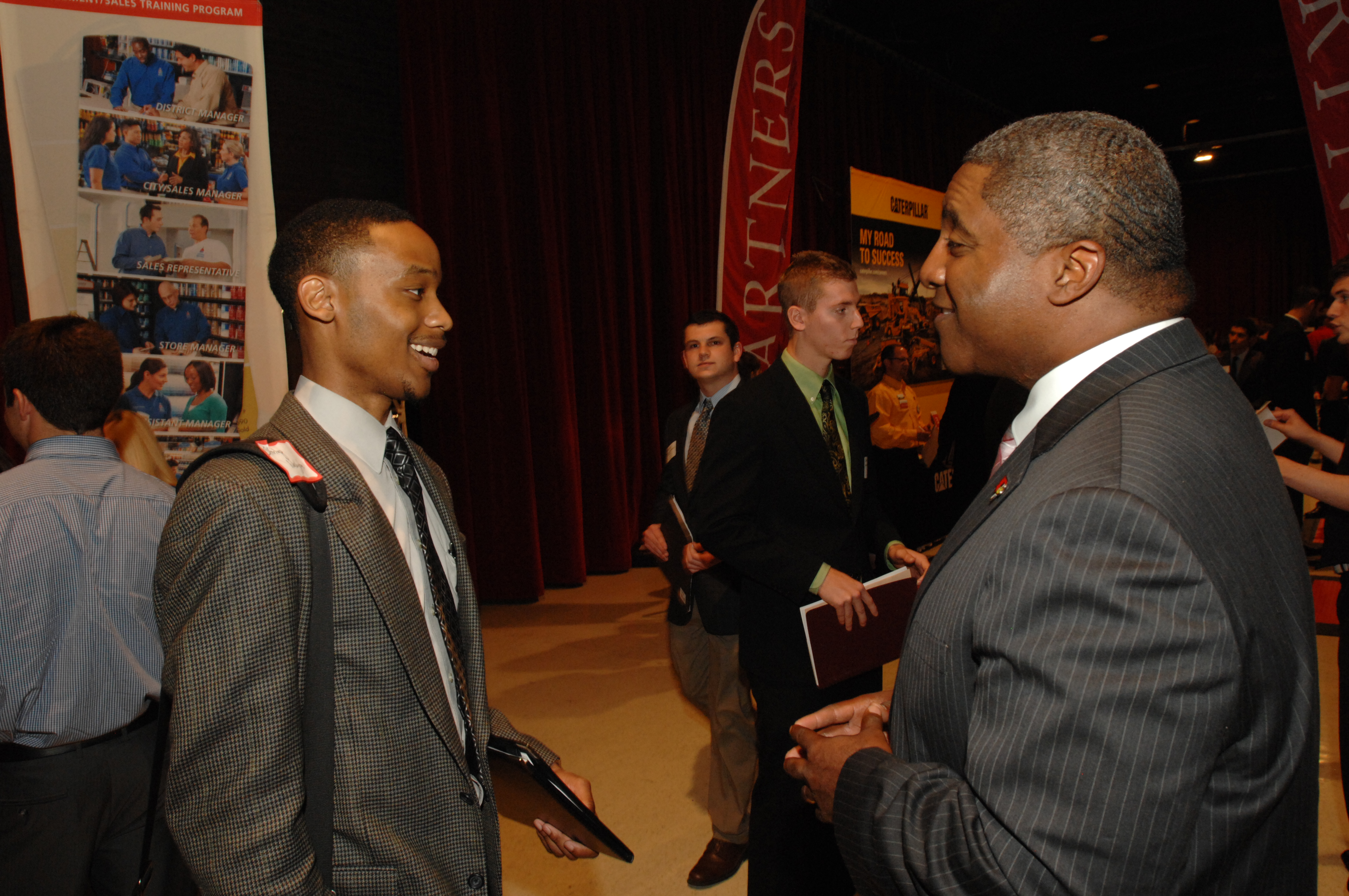 Drew Butts, Enterprise group talent manager (right), talks with an Illinois State student about his experience at a career fair.