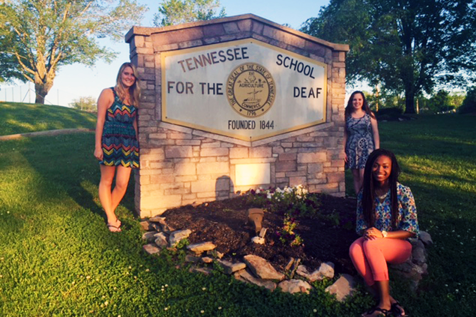 Deaf and Hard of Hearing major Maya Lane (right) in front of the school she and her fellow teacher candidates taught at during their spring 2016 semester before graduation.
