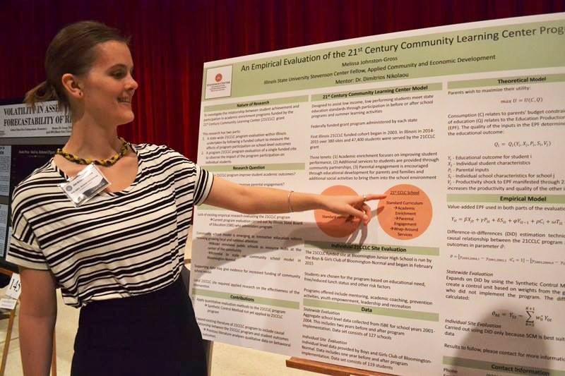 Student points to research poster