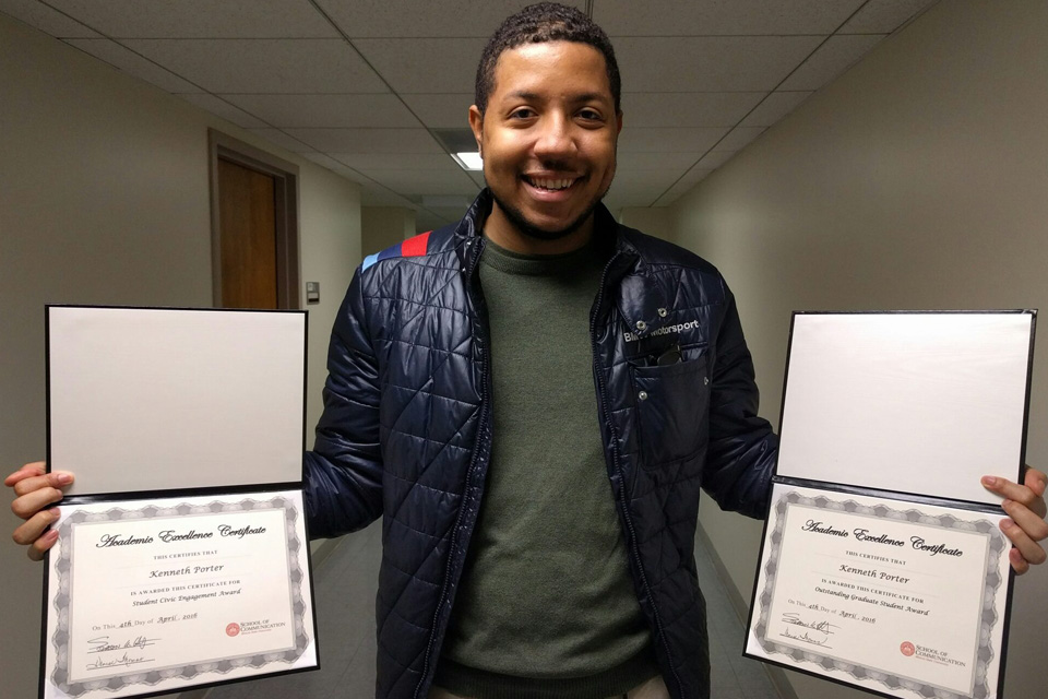 Kenneth Portter stands with two diplomas