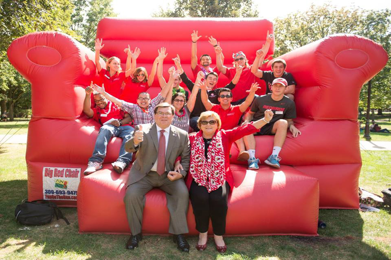 Dietz poses with students on giant red chair