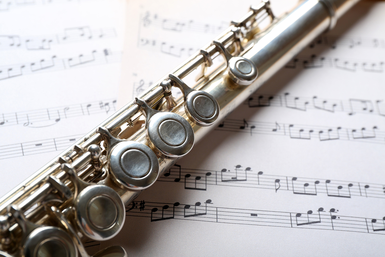 image of Silver flute on music notes background