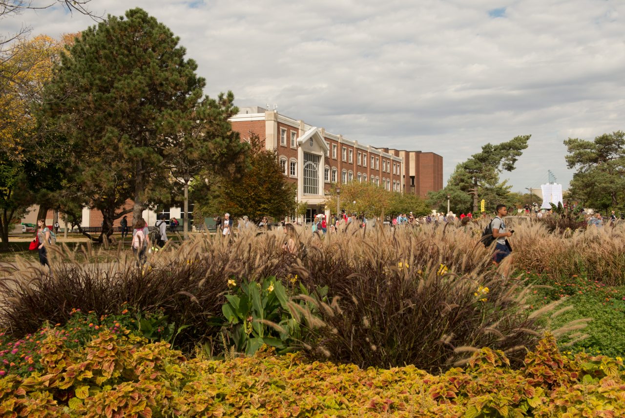 Students walking in front of Schroeder Hall on fall day.