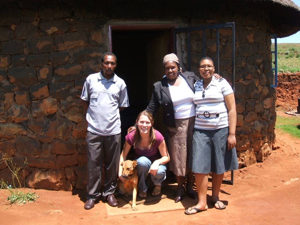 Emilie Gilde standing in front of home with 3 other people.