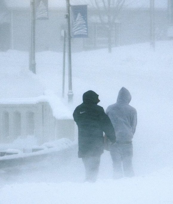two people walking in snowstorm