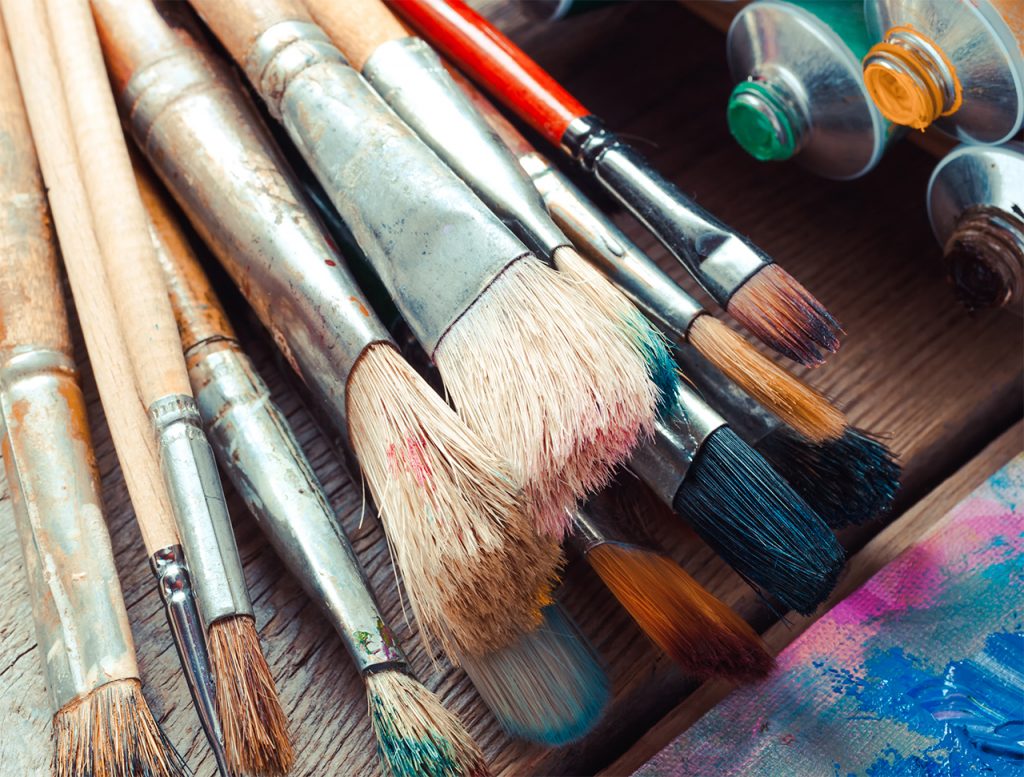 image of paintbrushes and paints placed on a table