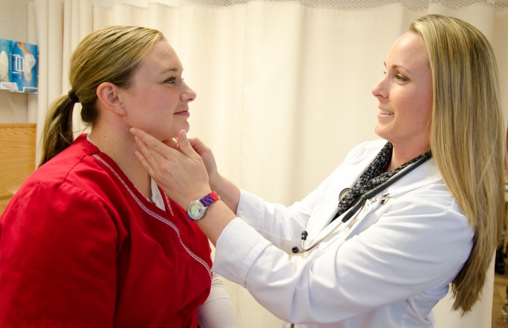 Nursing student examines patient