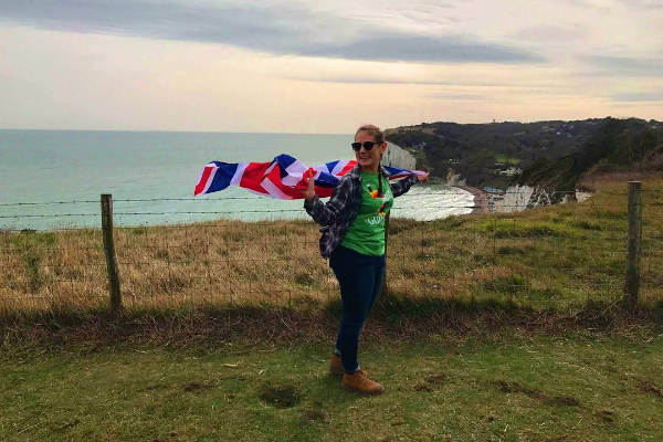 Photo of a student standing near cliff overlooking sea.
