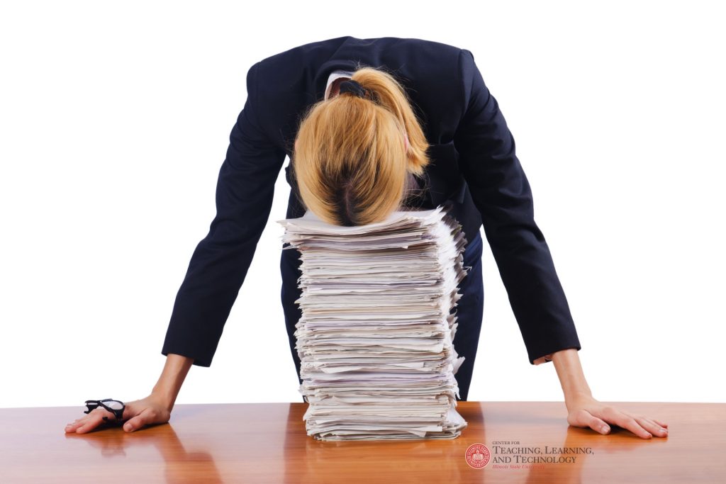 Instructor with head on stack of papers