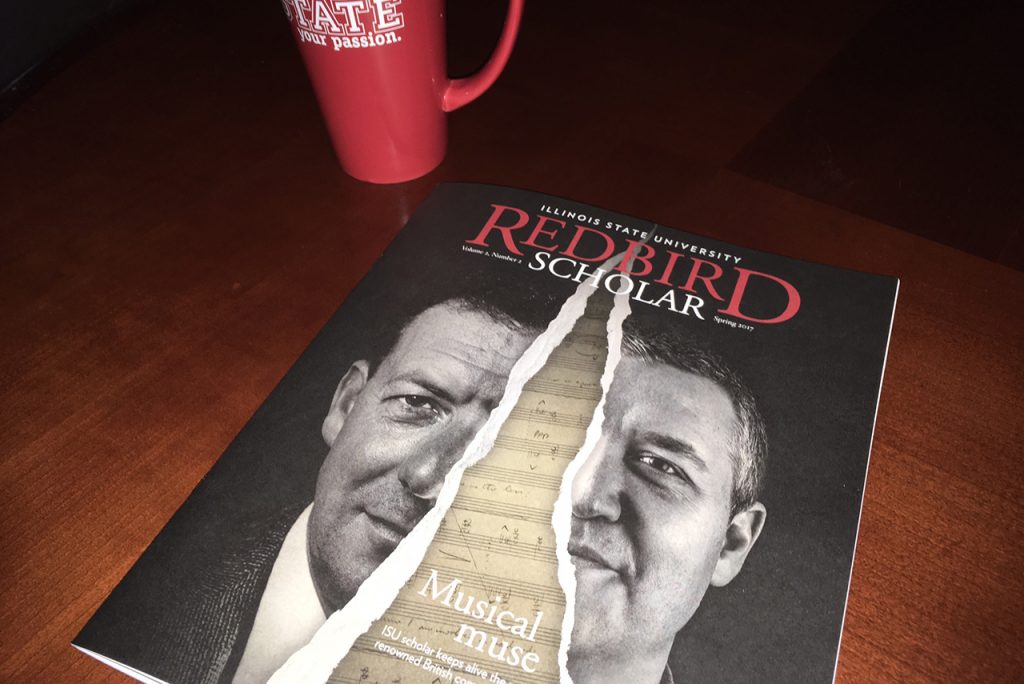 Redbird Scholar magazine on a table next to a coffee mug