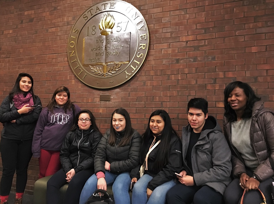 High schoolers pose under ISU seal