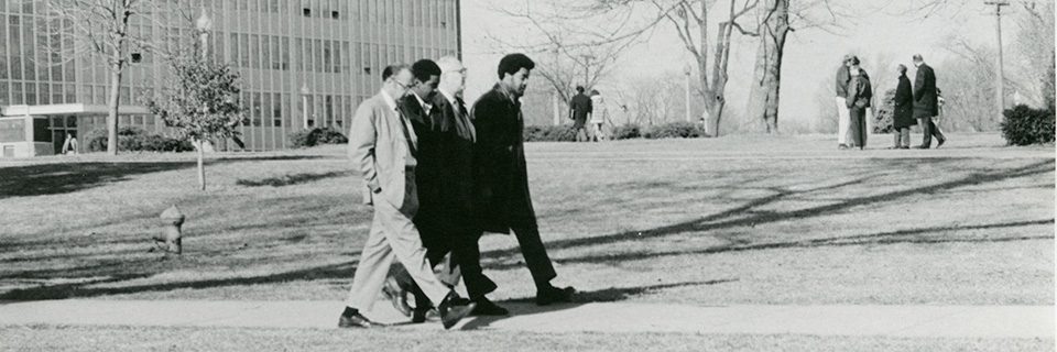 President Braden and another administrator walks with two black students on the Quad in 1969