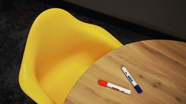 Two markers on a table next to a chair