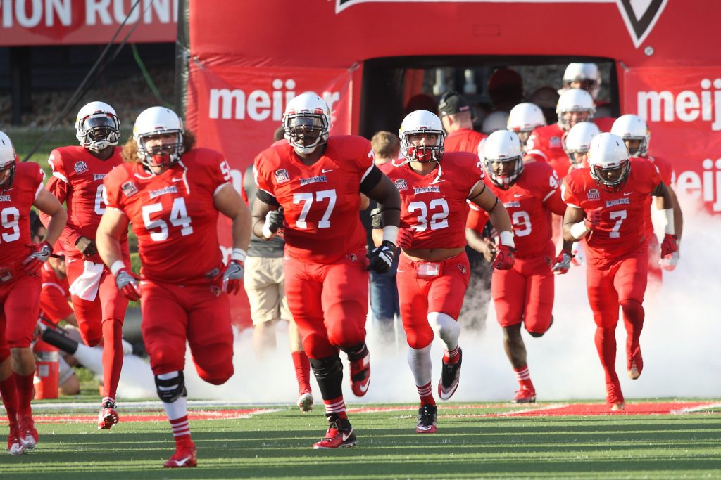 Redbird football players running onto the field