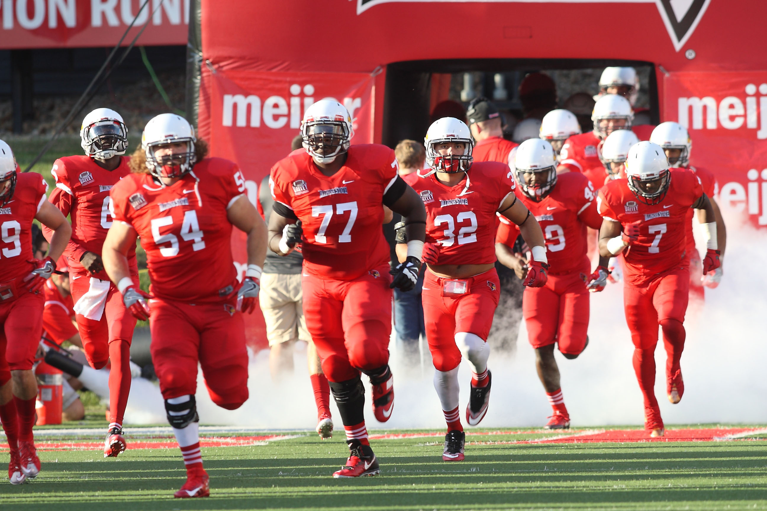 Redbird football players running onto the field