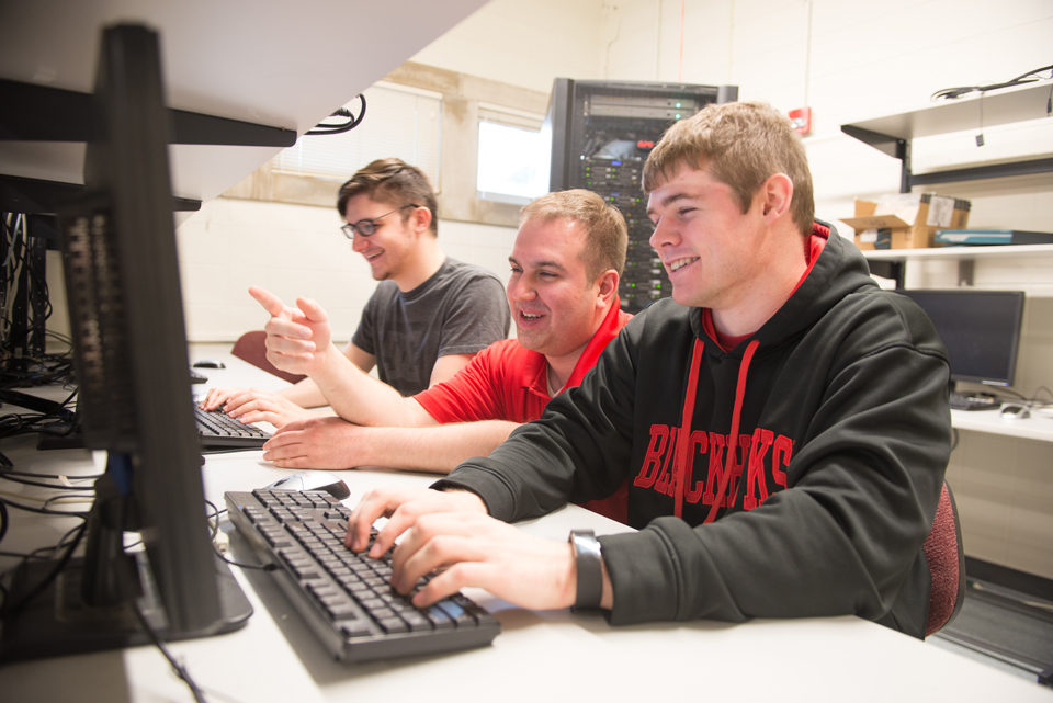 Computer Systems Technology students working with their professor.