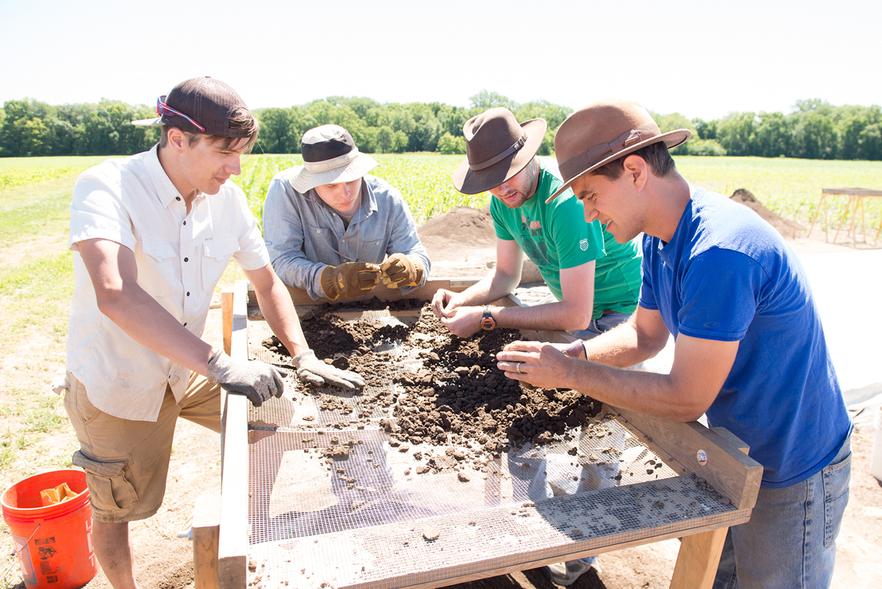 Illinois State Professor Logan Miller (front, right) and his students sift through the collected soil in search of artifacts.