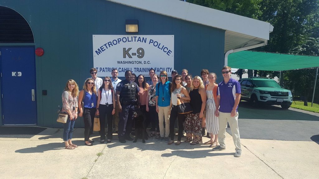 Kara Chrispen and a group of interns with a K-9 officer and his K-9, Kato.
