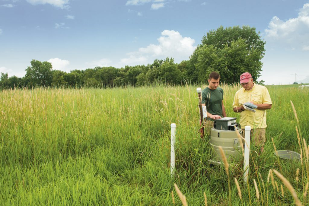 Professor Eric Peterson and graduate student Joe Miller set up a collection device near a tributary of Lake Evergreen to determine nitrate levels in the groundwater.