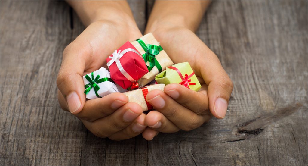 hands holding tiny gifts with smooth ribbons on them