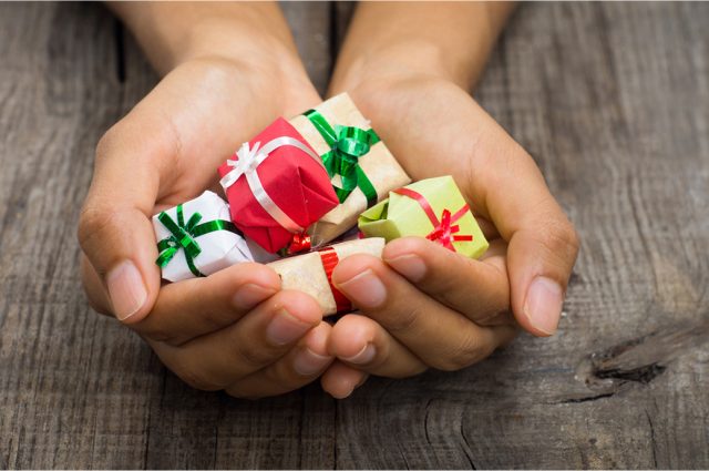 hands holding tiny gifts with smooth ribbons on them