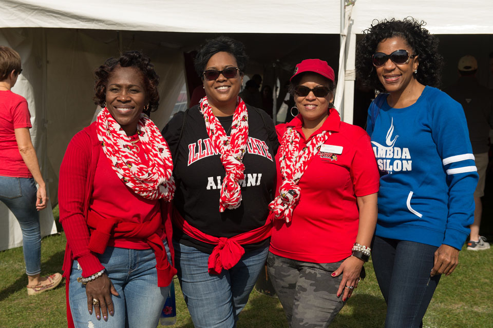 Four women smile at tailgate