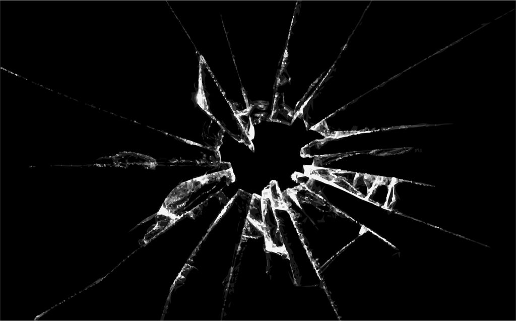 image of glass shattered by a bullet hole