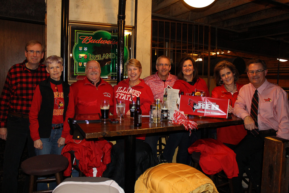 Group of people in red smiling at table