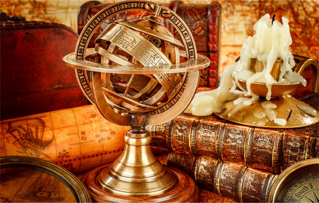 old sexton globe and books with a candle burned down to wax