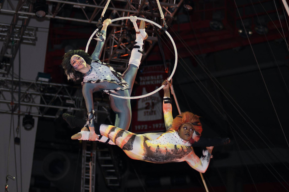 two people suspended in air by hoop