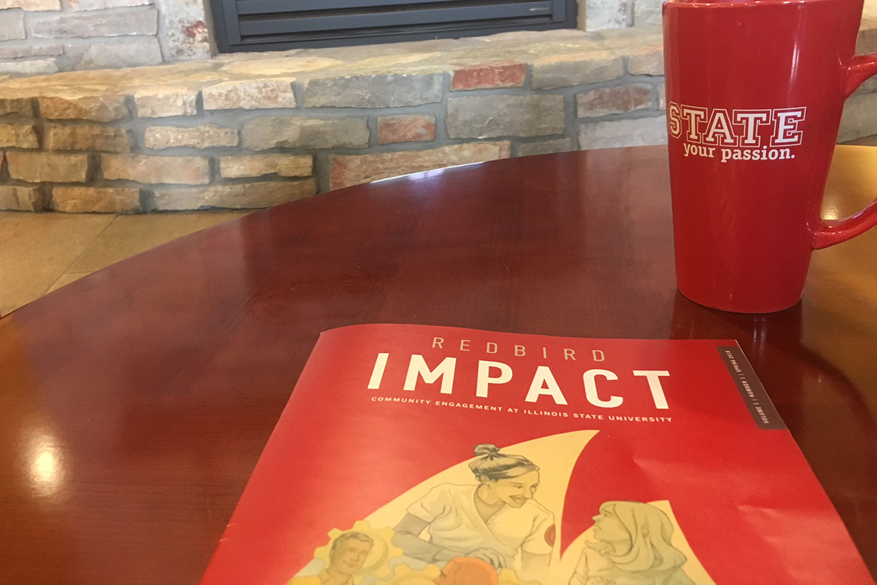 Redbird Impact magazine on table next to coffee mug and in front of fireplace