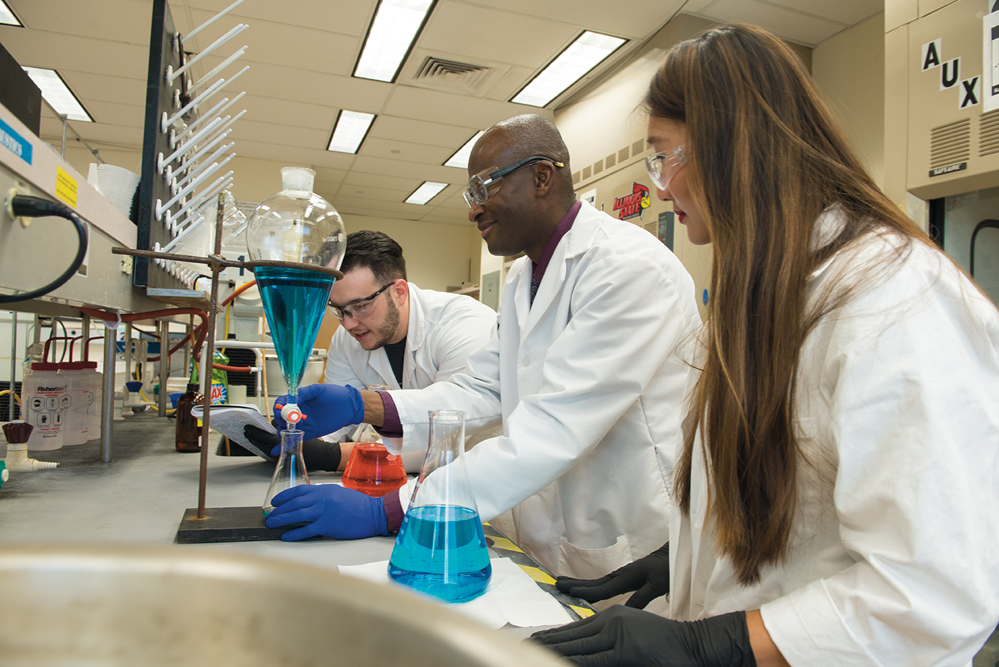 Professor Shawn Hitchcock (center) works in his research laboratory with students Stephanie Waggoner and Eric Jacobsen.