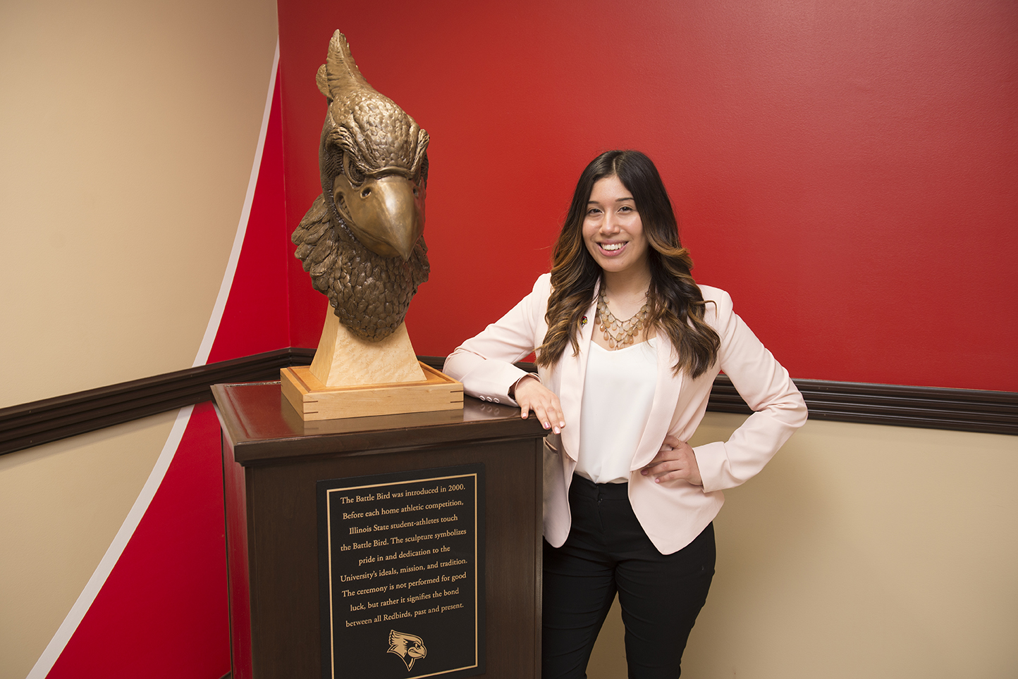 Sarah Aguilar standing by the Reggie bust in Hovey Hall.