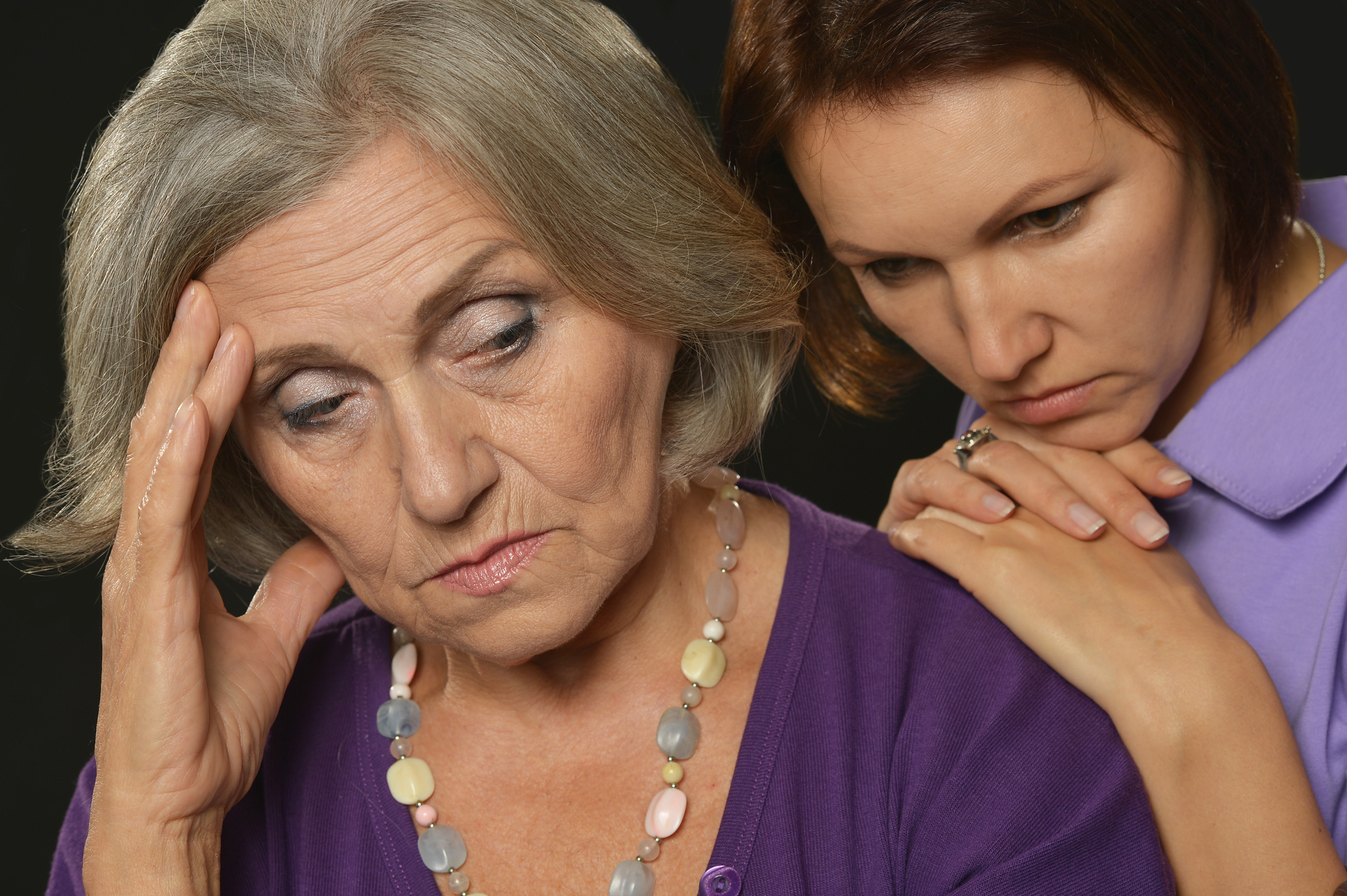 older mother upset and young woman leaning on her shoulder