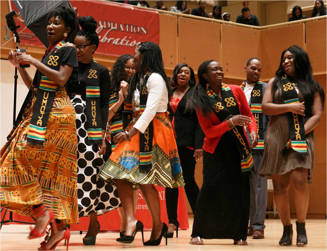 graduates dancing on stage as part of the Umoja celebration