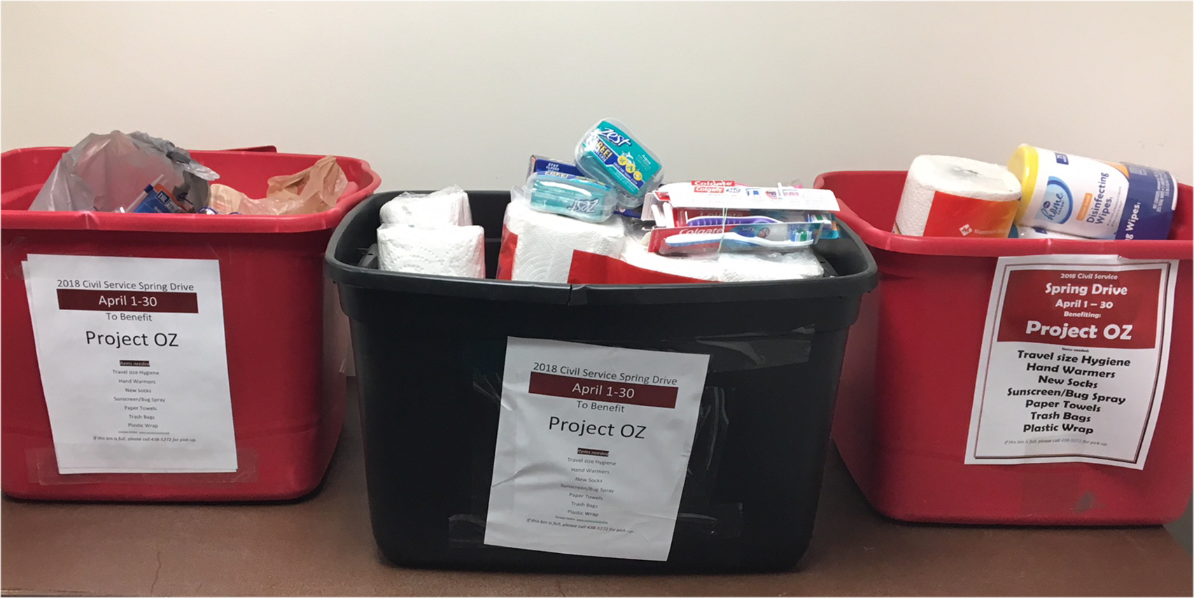 Three bins filled with toothbrushes, paper towels, soap and other items for teenagers in temporary housing.