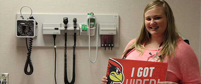 nurse holds "I Got Hired" sign
