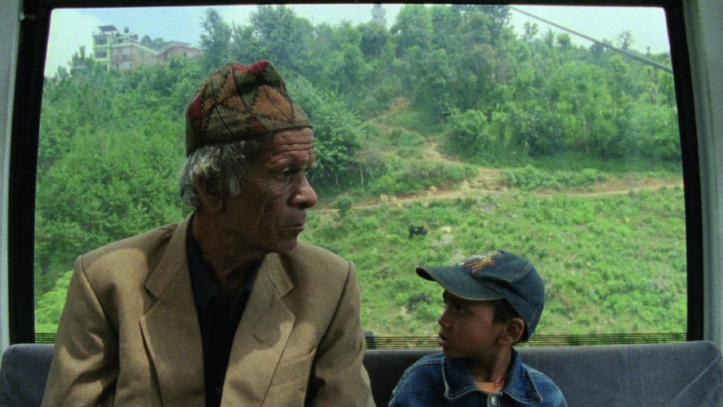 older man and a young boy in a tram in Nepal