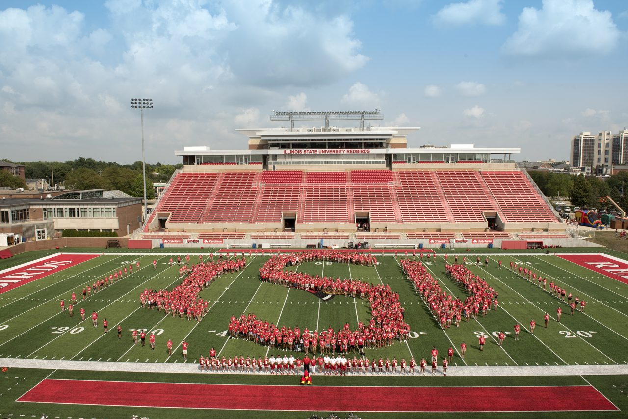 Group of students form the letters 'ISU' on the football field